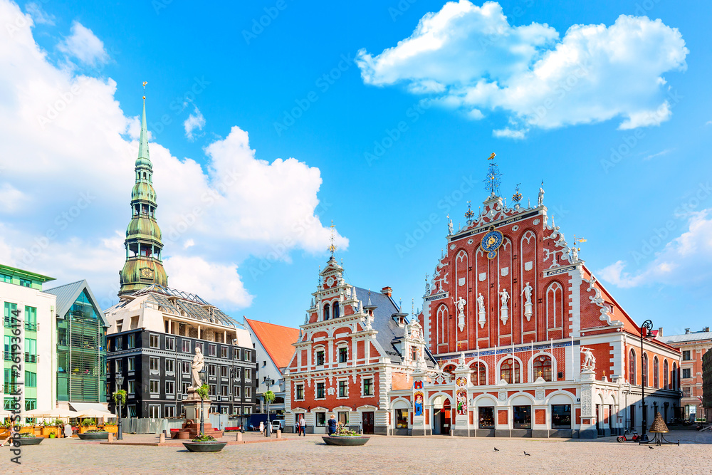 Fototapeta premium View of the Old Town Ratslaukums square, Roland Statue, The Blackheads House near St Peters Cathedral against blue sky in Riga, Latvia. Summer sunny day