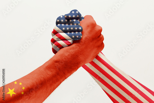 Trade war and rivalry. Two male hands competing in arm wrestling colored in China and America flags isolated on white studio background. Concept of economical and political relations, embargo. photo