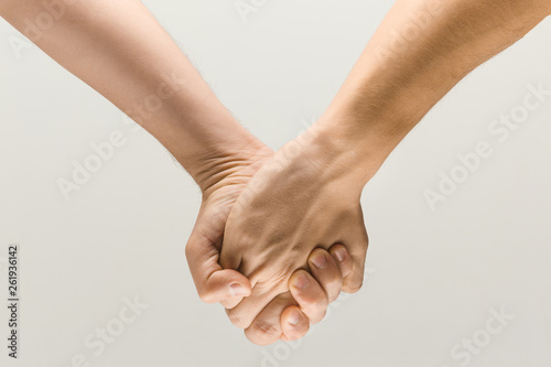 Let'go this way together. loseup shot of male holding hands isolated on grey studio background. Concept of human relations, friendship, partnership, business. Copyspace.