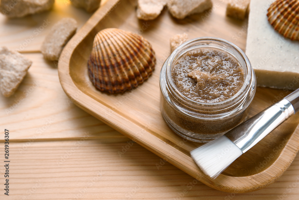 Jar with sugar scrub and ingredients on wooden table