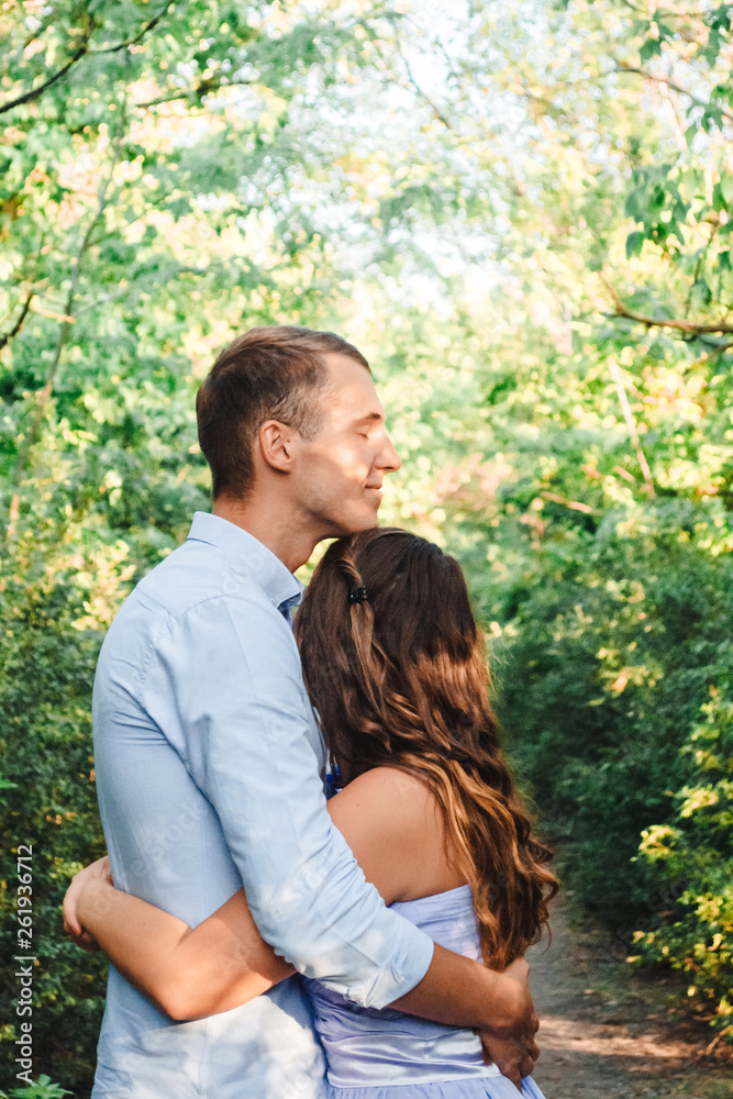 Couple in love smiling and hugging in trees tunnel. Man holding hands around woman. Tender and affectionate couple standing on nature background. Happy couple in love. Cope space Couple in love smiling and hugging in trees tunnel. Man holding hands around woman. Tender and affectionate couple standing on nature background. Happy couple in love. Cope space