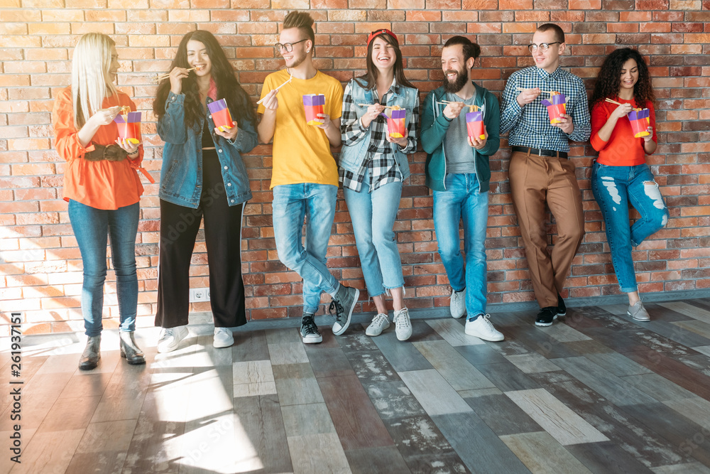 Obraz premium Millennials lifestyle. Diverse team. Casual clothes. Takeaway meal. Open loft workspace. Friendly relaxed atmosphere