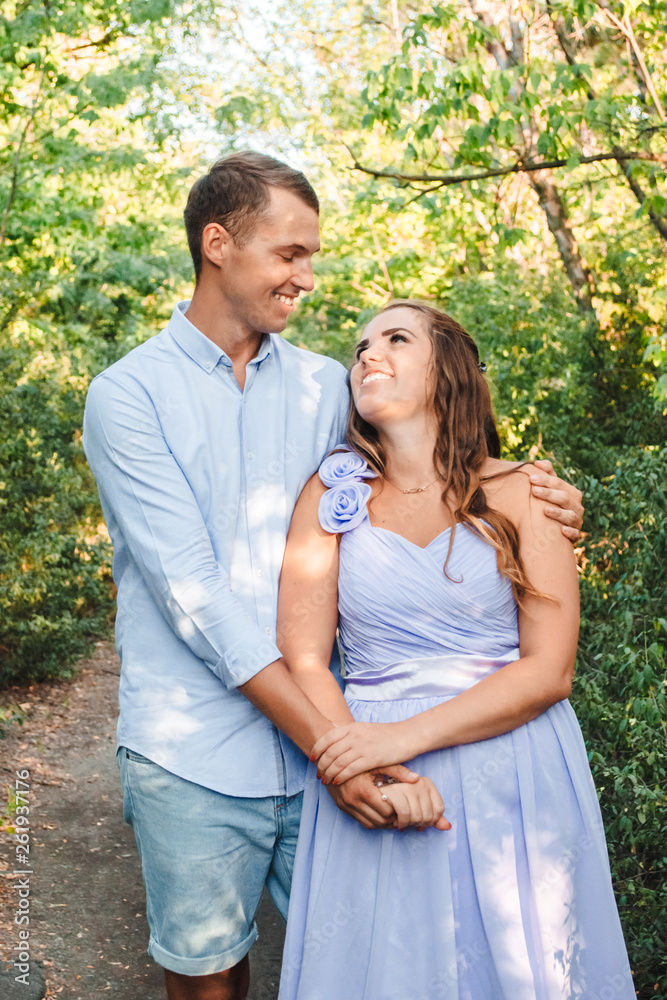 Couple in love smiling and hugging in trees tunnel. Man holding hands around woman. Tender and affectionate couple standing on nature background. Young beautiful couple. Happy couple in love Couple in love smiling and hugging in trees tunnel. Man holding hands around woman. Tender and affectionate couple standing on nature background. Young beautiful couple. Happy couple in love