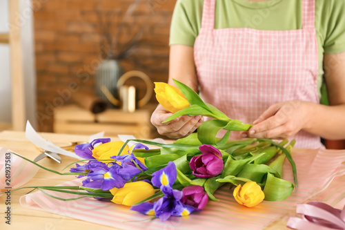 Florist making beautiful bouquet at table