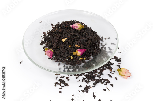 Tea leaves with chinese rose buds on saucer and beside
