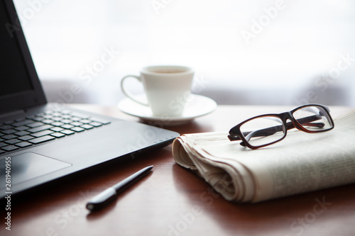 Newspaper with computer on table. Coffee break. 