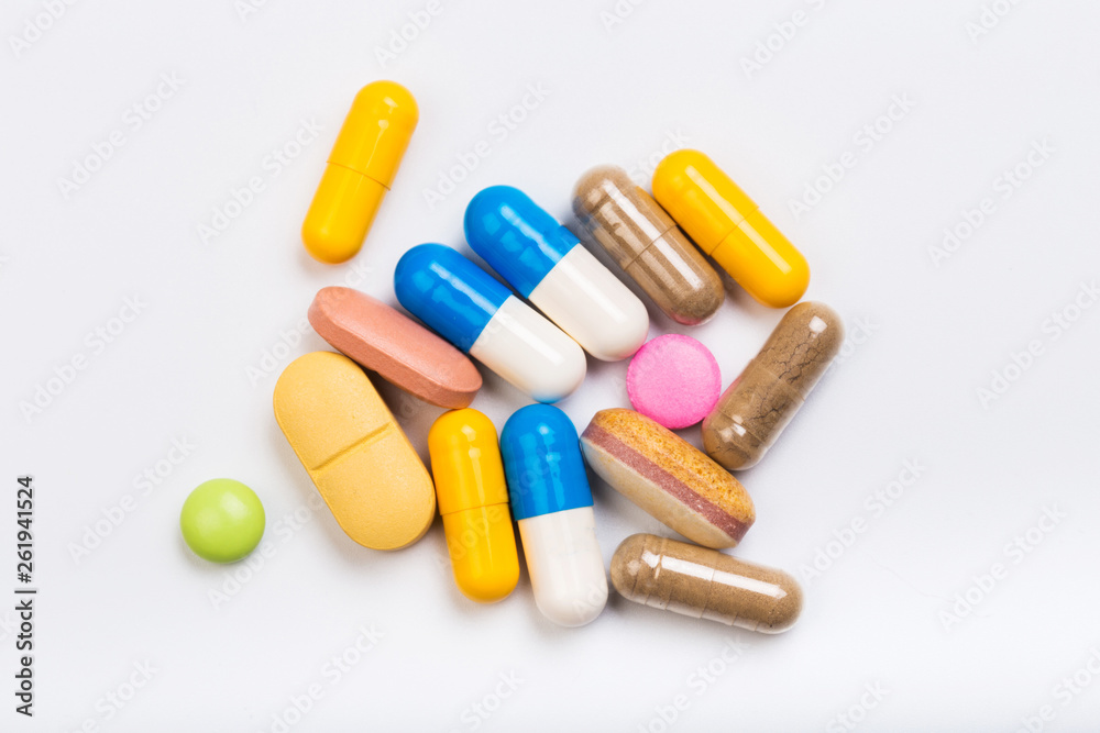 set of multi-colored tablets and capsules on a white background set of multi-colored tablets and capsules on a white background