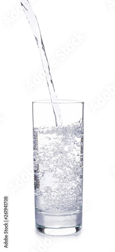Pouring of water into glass on white background