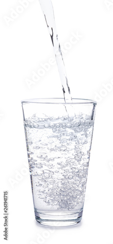 Pouring of water into glass on white background