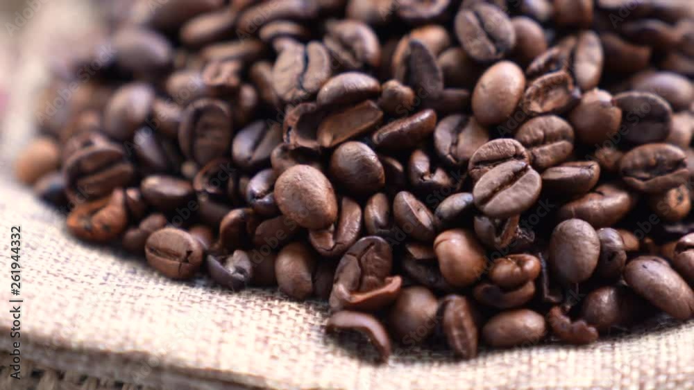 Black Coffee Grains. Black coffee is laid out on a bag spinning on a stand around its axis.