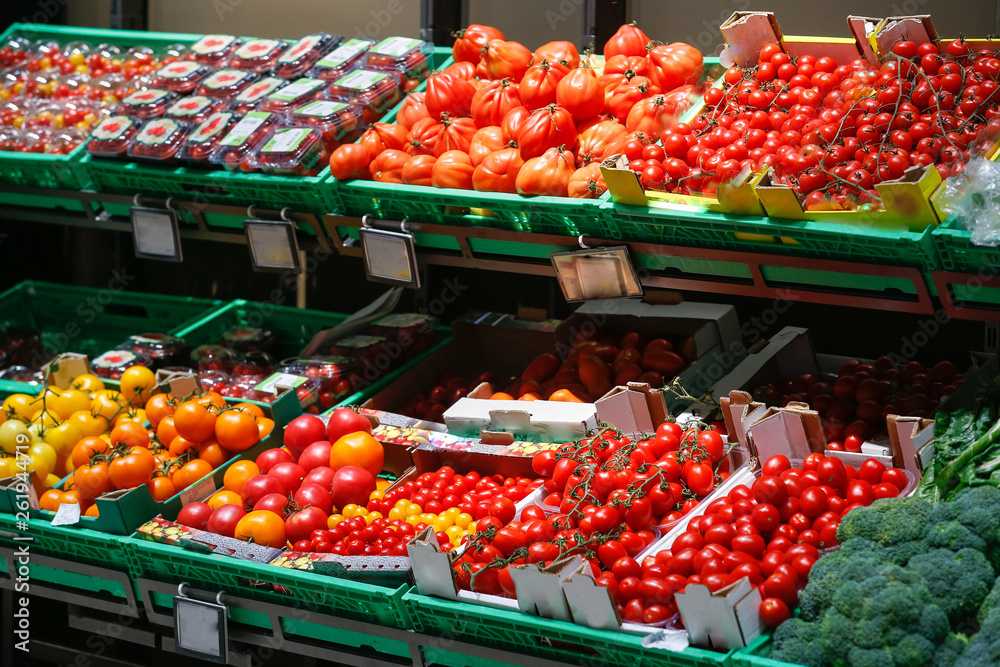 Unpacked, fresh assortment of tomatoes in a self-service supermarket.