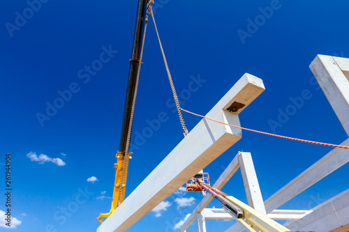 Worker is helping crane from the ground, keep balance and direction