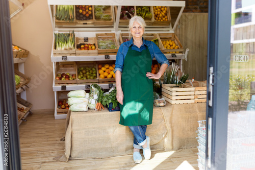 Foto Senior woman working in small grocery store