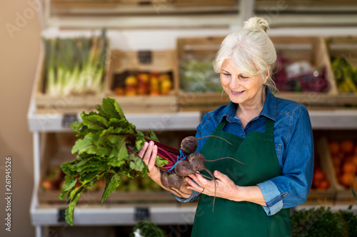 Senior woman working in small grocery store