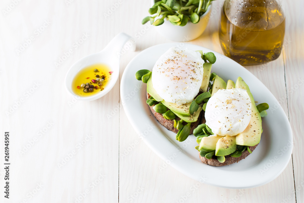 Avocado toast, cherry tomato on wooden background. Breakfast with toast avocado, vegetarian food, healthy diet concept. Healthy sandwich with avocado and poached eggs. Avocado toast, cherry tomato on wooden background. Breakfast with toast avocado, vegetarian food, healthy diet concept. Healthy sandwich with avocado and poached eggs.