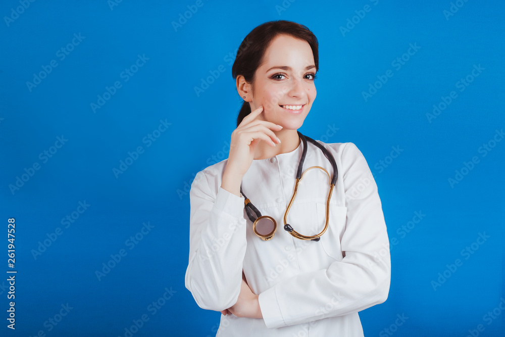 A young female doctor in white clothes on a blue background A young female doctor in white clothes on a blue background