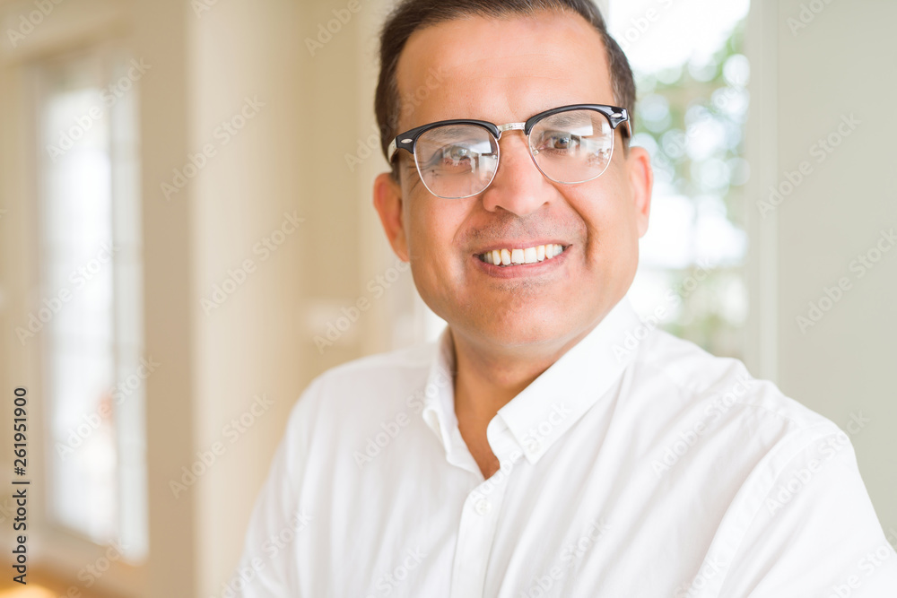 Middle age man wearing glasses smiling to the camera at home Middle age man wearing glasses smiling to the camera at home