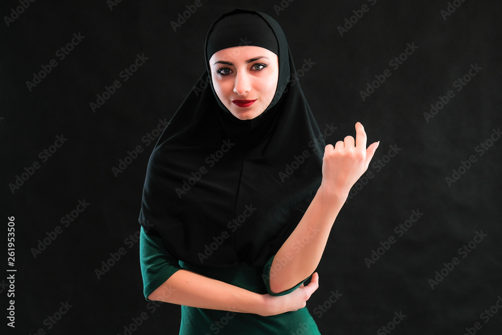 Concept Beauty sexy fashion model woman in hijab portrait, with long beautiful hair on black background standing. Beautiful young brunette girl posing in studio. Concept Beauty sexy fashion model woman in hijab portrait, with long beautiful hair on black background standing. Beautiful young brunette girl posing in studio.