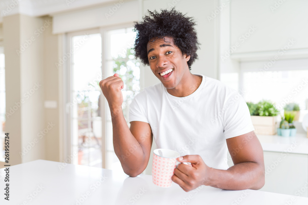 African American man with afro hair drinking a cup of coffee screaming proud and celebrating victory and success very excited, cheering emotion African American man with afro hair drinking a cup of coffee screaming proud and celebrating victory and success very excited, cheering emotion