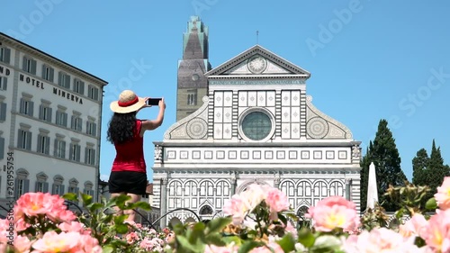 Female tourist taking picture of Santa Maria Novella church, Florence, Italy. Caucasian woman with camera traveling to Tuscany, things to do, photo holidays in Europe, sightseeing of Italian tour