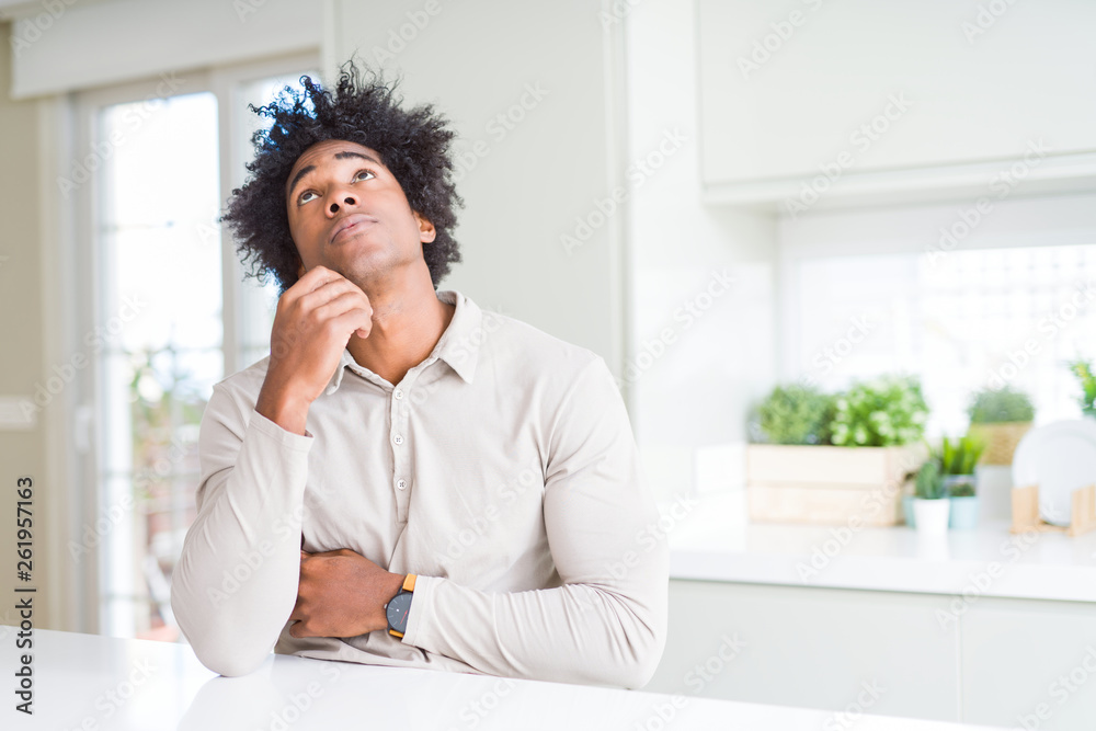 African American man at home with hand on chin thinking about question, pensive expression. Smiling with thoughtful face. Doubt concept. African American man at home with hand on chin thinking about question, pensive expression. Smiling with thoughtful face. Doubt concept.