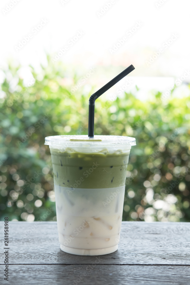 Iced matcha on wood table with blur nature background Iced matcha on wood table with blur nature background