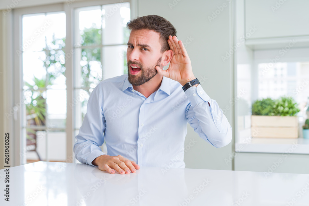 Handsome business man smiling with hand over ear listening an hearing to rumor or gossip. Deafness concept. Handsome business man smiling with hand over ear listening an hearing to rumor or gossip. Deafness concept.