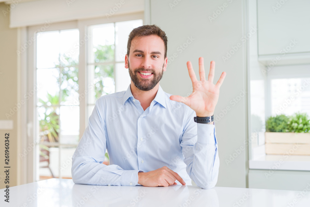 Handsome business man showing and pointing up with fingers number five while smiling confident and happy.