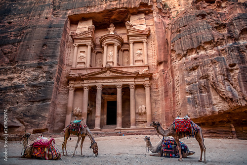 Camels are laying and standing in front of the Al Khazneh tomb. The Treasury tomb of Petra, Jordan - Image, selective focus photo