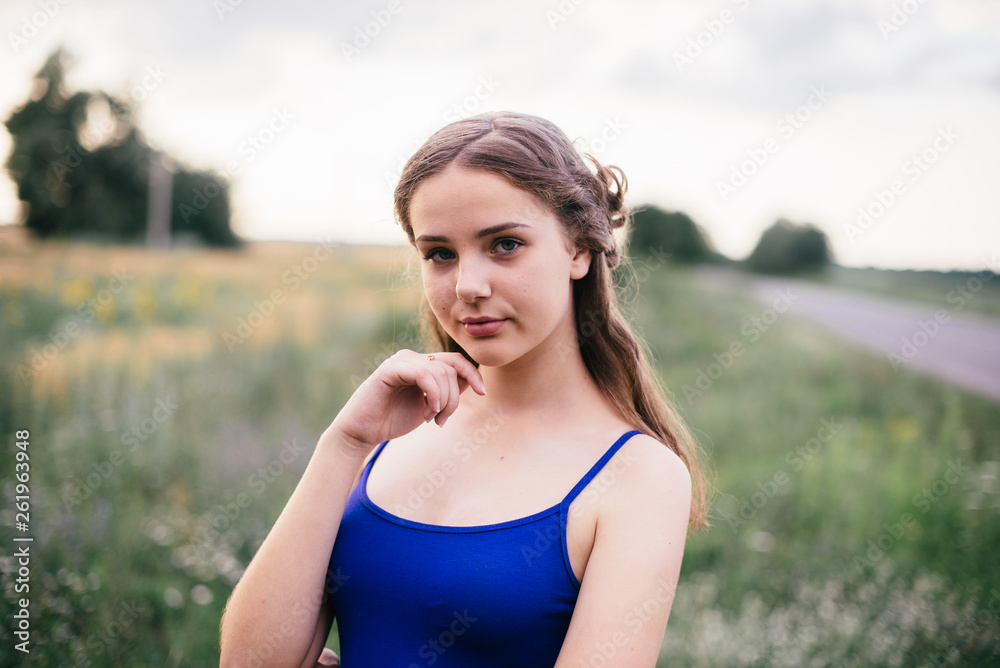 Beautiful girl in short shorts and in a blue T-shirt on the field Beautiful girl in short shorts and in a blue T-shirt on the field