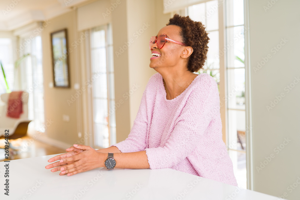 Beautiful young african woman with afro hair wearing funny pink heart glasses Beautiful young african woman with afro hair wearing funny pink heart glasses