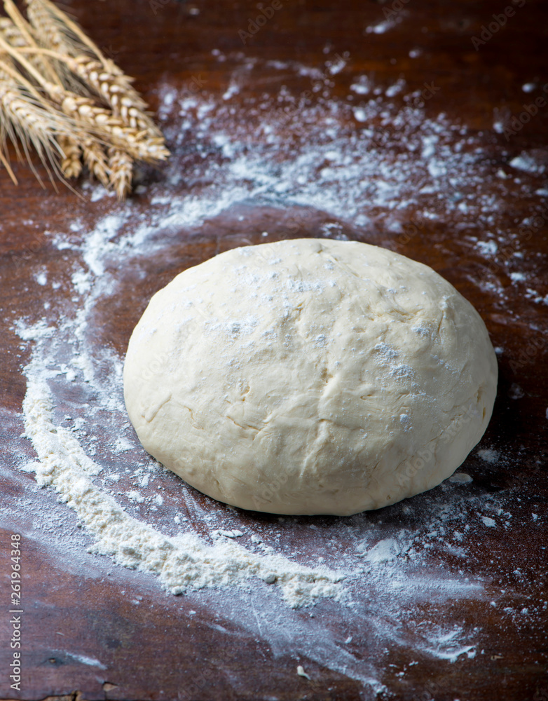 Circle of dough on a black background in flour Circle of dough on a black background in flour