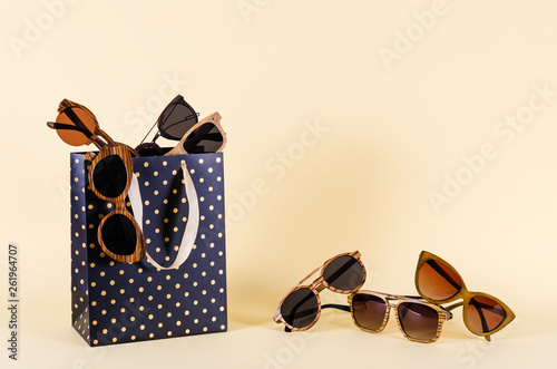 Sunglasses sale. Summer sale-out offer. Sunglasses in wooden frame on yellow background. Copy space. For banner