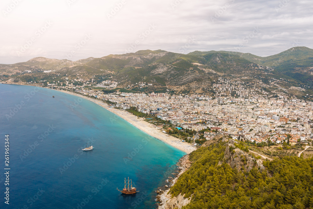 the coastline on the background of the city and mountains. Turkey, Alanya. Top view