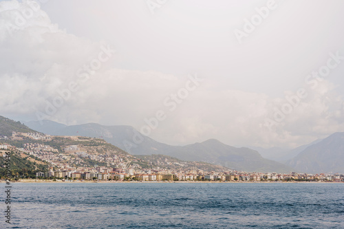 the coastline on the background of the city and mountains © magic_cinema