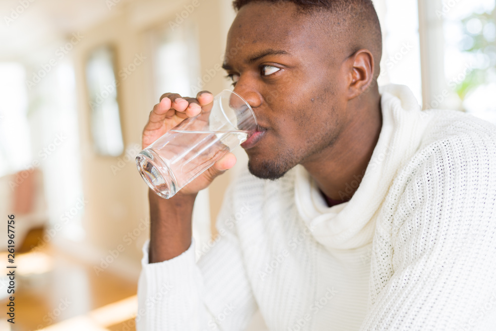 Young african american man drinking a fresh glass of water Young african american man drinking a fresh glass of water