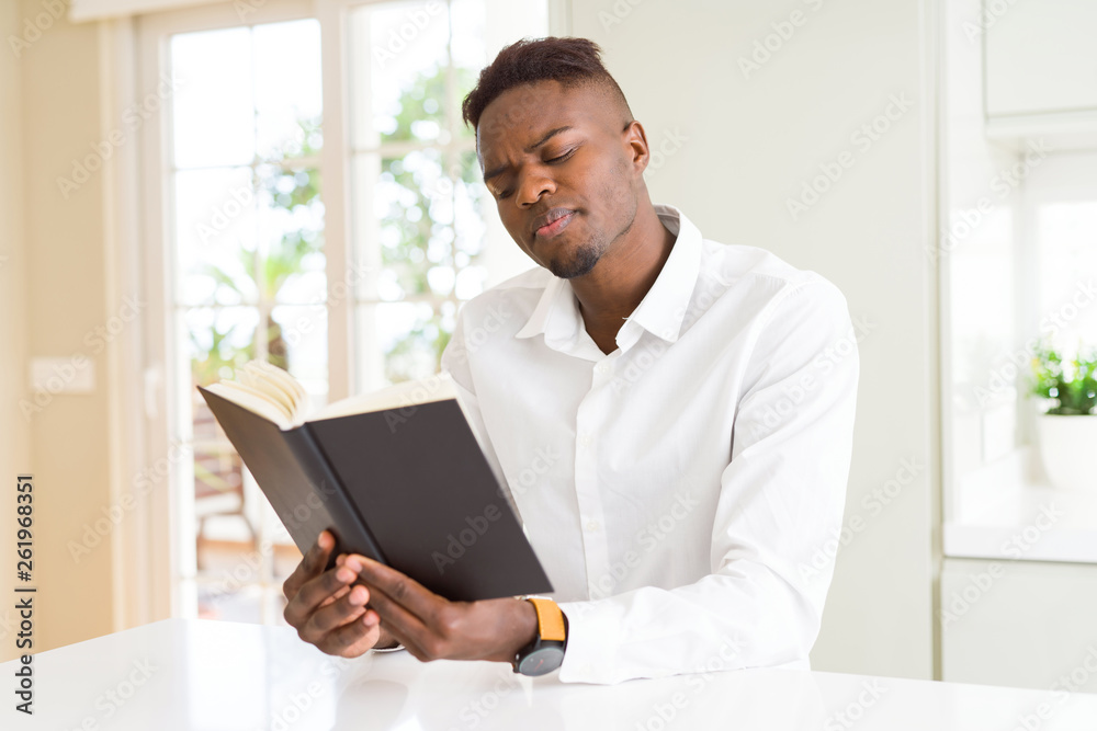 Young african man reading a book, studying for univeristy Young african man reading a book, studying for univeristy