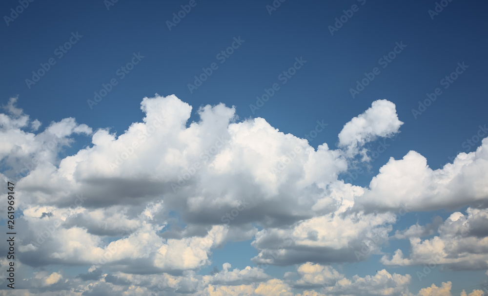 Beautiful fluffy clouds in the blue sky. City landscape. Good weather.