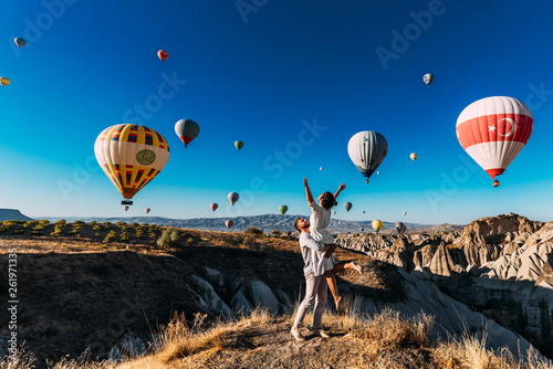Couple in love among balloons. A guy proposes to a girl. Couple in love in Cappadocia. Couple in Turkey. Honeymoon in the mountains. Man and woman traveling. Flying on balloons. Wedding. Journey. Love photo