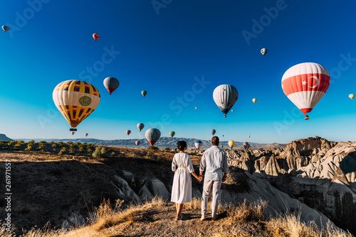 Wedding travel. Honeymoon trip. Couple in love among balloons. A guy proposes to a girl. Couple in love in Cappadocia. Couple in Turkey.  Man and woman traveling. Flying on balloons. Tourists photo