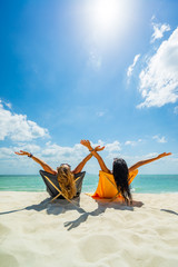 Two Women enjoying their holidays on a transat at the tropical beach