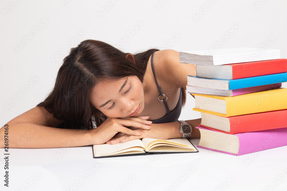 Exhausted Young Asian woman sleep with books on table. Exhausted Young Asian woman sleep with books on table.