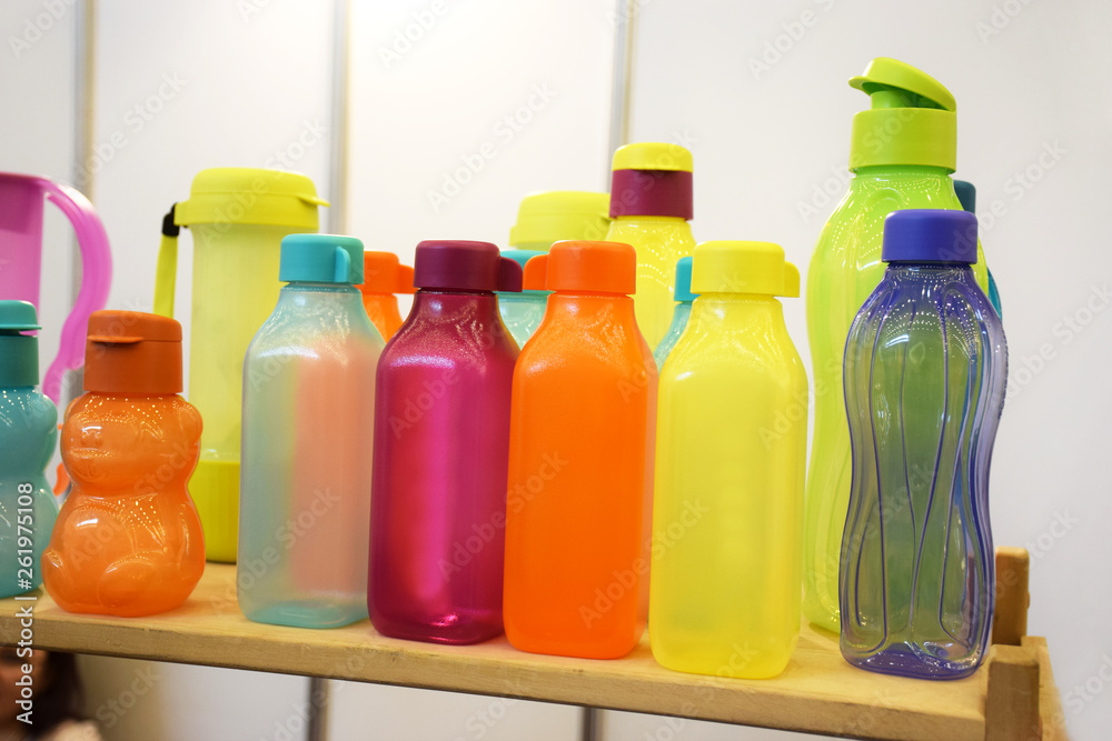 Group of empty sports water bottles of different colors and shapes on white background. Bright empty polyethylene bottles and tableware for fresh drinks. Group of empty sports water bottles of different colors and shapes on white background. Bright empty polyethylene bottles and tableware for fresh drinks.