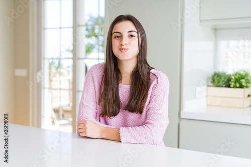 Beautiful young woman wearing pink sweater puffing cheeks with funny face. Mouth inflated with air, crazy expression. Free Download Beautiful young woman wearing pink sweater puffing cheeks with funny face. Mouth inflated with air, crazy expression. - GFXLoad