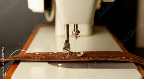 Background type of sewing machine, leather belt sewing process. Leather workshop. photo