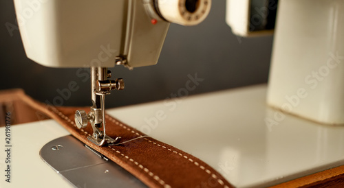 Background type of sewing machine, leather belt sewing process. Leather workshop.
