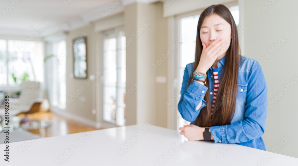 Young beautiful asian woman with long hair wearing denim jacket bored yawning tired covering mouth with hand. Restless and sleepiness. Young beautiful asian woman with long hair wearing denim jacket bored yawning tired covering mouth with hand. Restless and sleepiness.