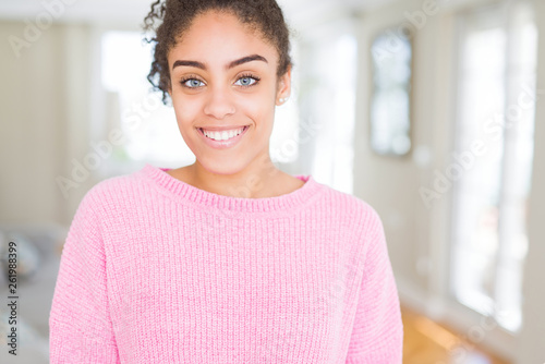 Beautiful young african american woman with afro hair with a happy and cool smile on face. Lucky person.