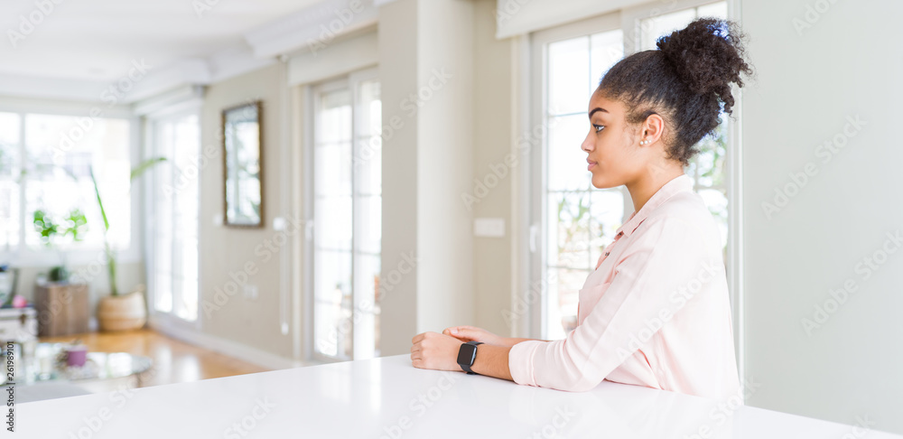 Wide angle of beautiful african american woman with afro hair looking to side, relax profile pose with natural face and confident smile. Wide angle of beautiful african american woman with afro hair looking to side, relax profile pose with natural face and confident smile.