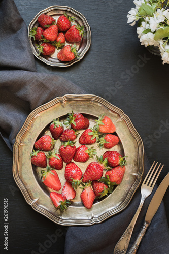 Sweet organic strawberry in vintage plate on dark. Summer. Top view.